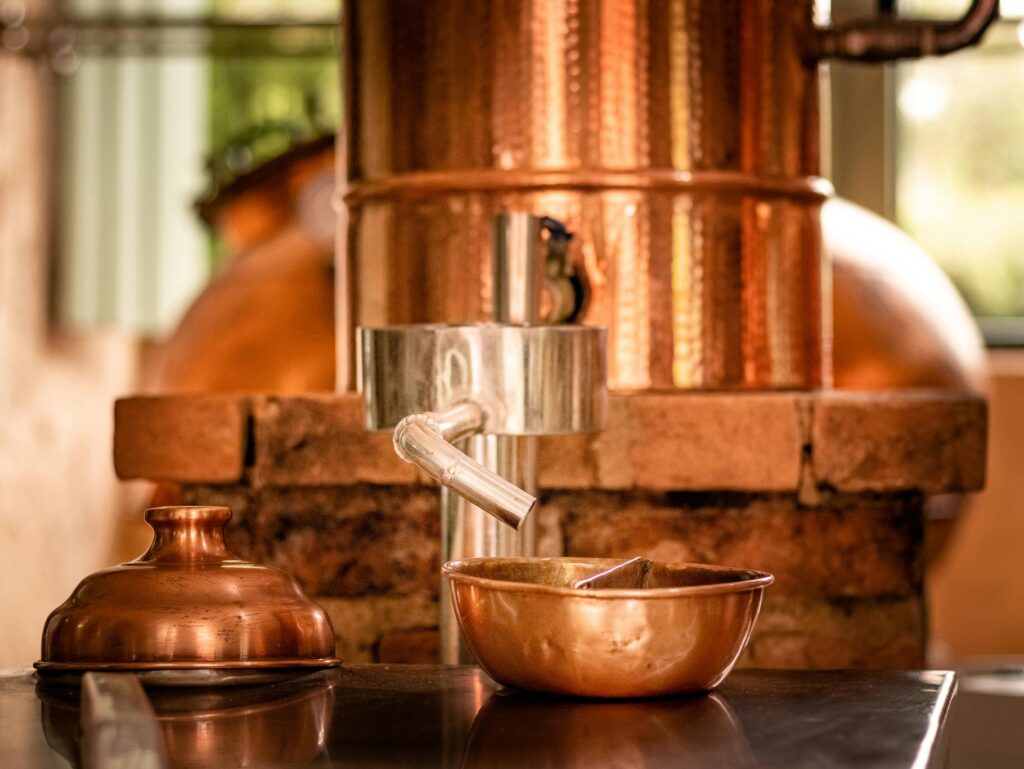 Close-up of copper distillery apparatus with shiny copper bowls.